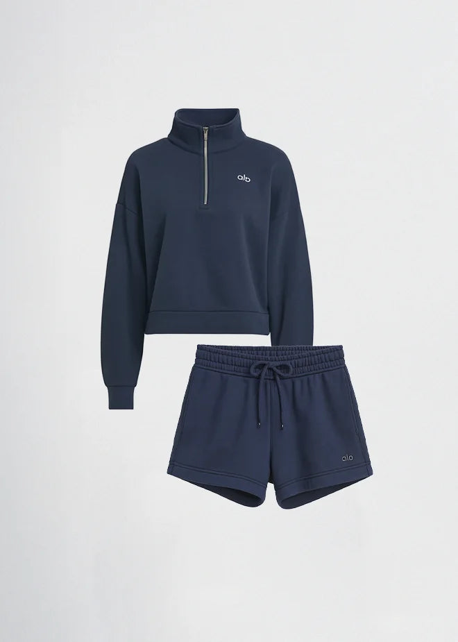 Woman wearing a cream-colored Adidas tracksuit on a light gray background